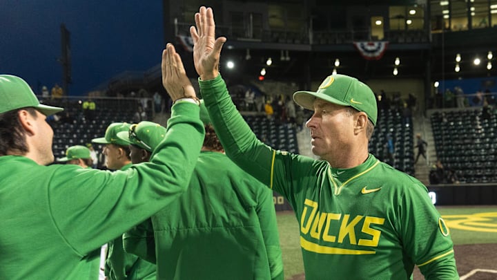 Oregon baseball coach Mark Wasikowski, right, congratulates this team after their season-opening win over George Mason at PK Park in Eugene Feb. 13, 2026.