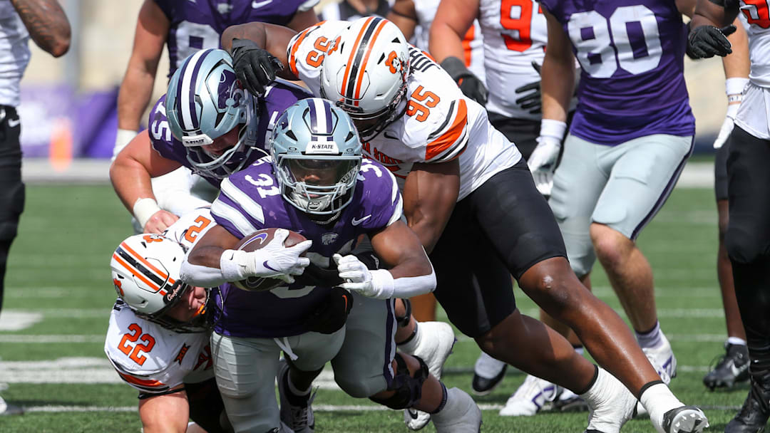 Sep 28, 2024; Manhattan, Kansas, USA; Kansas State Wildcats running back DJ Giddens (31) is tackled by Oklahoma State Cowboys linebacker Jeff Roberson (22) and defensive end Jaleel Johnson (95) during the fourth quarter at Bill Snyder Family Football Stadium. Mandatory Credit: Scott Sewell-Imagn Images
