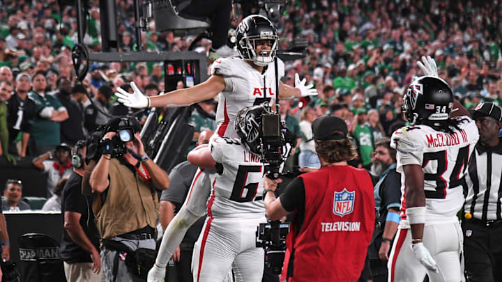 Atlanta Falcons wide receiver Drake London gets a lift from All-Pro guard Chris Lindstrom after scoring the game winner against the Philadelphia Eagles.