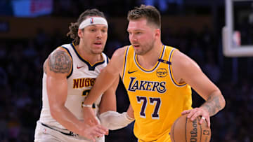 Mar 19, 2025; Los Angeles, California, USA;  Los Angeles Lakers guard Luka Doncic (77) is guarded by Denver Nuggets forward Aaron Gordon (32) in the first half at Crypto.com Arena. Mandatory Credit: Jayne Kamin-Oncea-Imagn Images