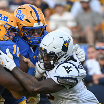 Sep 14, 2024; Pittsburgh, Pennsylvania, USA; West Virginia Mountaineers defenders T.J. Jackson (11) and  Tyrin Bradley Jr. (8) sack Pittsburgh Panthers quarterback Eli Holstein (10) during the fourth quarter at Acrisure Stadium. Mandatory Credit: Barry Reeger-Imagn Images