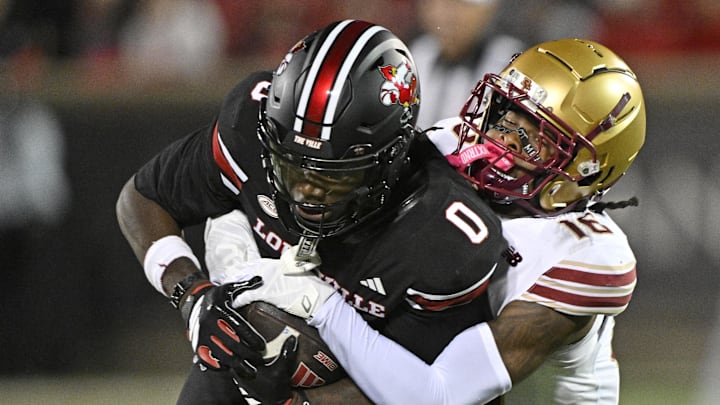 Oct 25, 2025; Louisville, Kentucky, USA;  Louisville Cardinals wide receiver Chris Bell (0) battles for more yardage against Boston College Eagles defensive back Isaiah Farris (16) during the second half at L&N Federal Credit Union Stadium. Mandatory Credit: Jamie Rhodes-Imagn Images