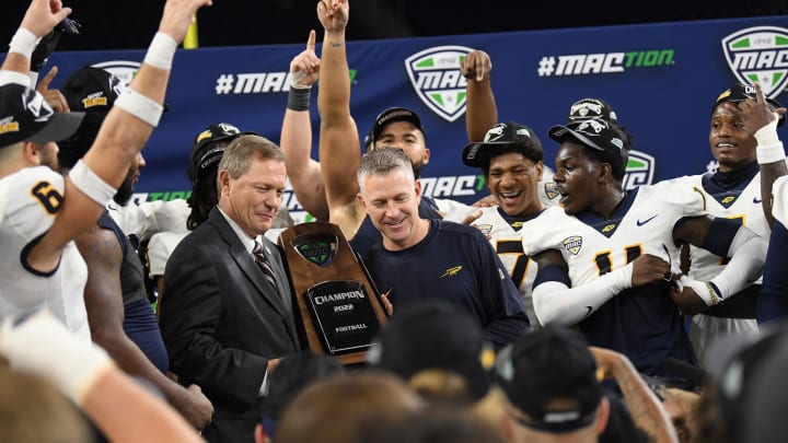 Dec 3, 2022; Detroit, Michigan, USA;  MAC Commisioner Dr. Jon Steinbrecher (center left) hands the MAC Championship trophy to Toledo head coach Jason Candle  after Toledo beat Ohio University at Ford Field. Mandatory Credit: Lon Horwedel-USA TODAY Sports