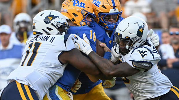 West Virginia Mountaineers defenders T.J. Jackson (11) and  Tyrin Bradley Jr. (8)