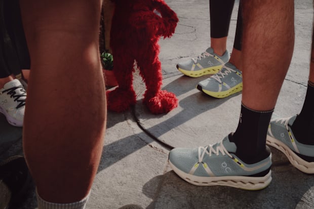 Elmo stands next to runners.