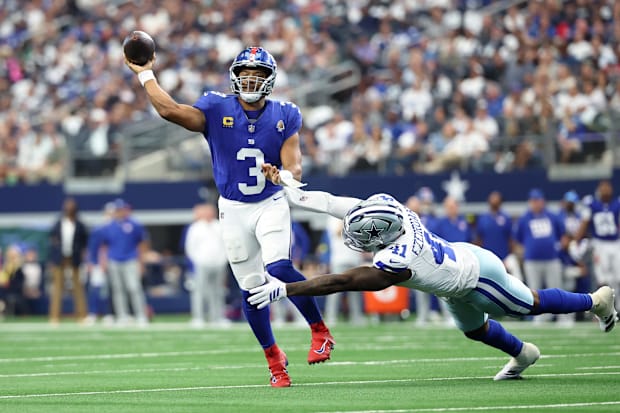New York Giants quarterback Russell Wilson passes the ball against Dallas Cowboys defensive end Donovan Ezeiruaku