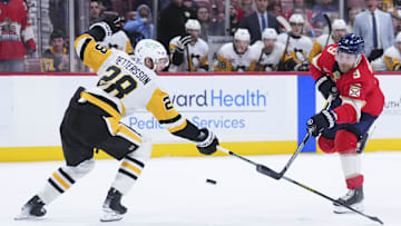 Jan 3, 2025; Sunrise, Florida, USA; Florida Panthers center Sam Bennett (9) shoots the puck against  Pittsburgh Penguins defenseman Marcus Pettersson (28) during the first period at Amerant Bank Arena. Mandatory Credit: Rich Storry-Imagn Images
