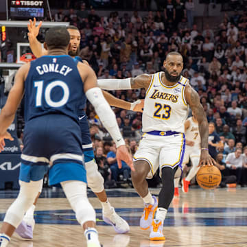 Apr 27, 2025; Minneapolis, Minnesota, USA; Los Angeles Lakers forward LeBron James (23) dribbles with Minnesota Timberwolves forward Jaden McDaniels (3), guard Mike Conley (10) and center Rudy Gobert (27) on defense in the second quarter during game four of first round for the 2025 NBA Playoffs at Target Center. Mandatory Credit: Matt Blewett-Imagn Images