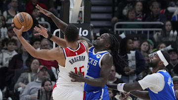 Nov 30, 2024; Milwaukee, Wisconsin, USA; Milwaukee Bucks forward Taurean Prince (12) defends against Washington Wizards guard Malcolm Brogdon (15) while driving to the basket in the first half at Fiserv Forum. Mandatory Credit: Michael McLoone-Imagn Images
