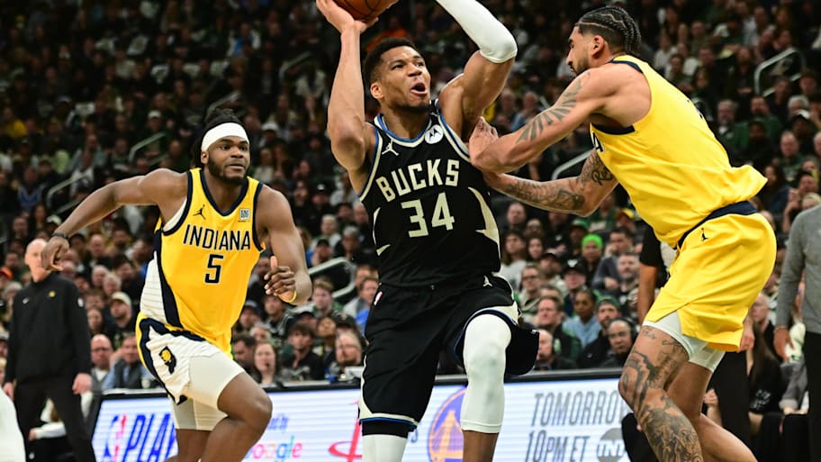 Bucks forward Giannis Antetokounmpo takes a shot against Pacers forward Obi Toppin and forward Jarace Walker.