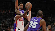 Houston Rockets guard Jalen Green drives between Phoenix Suns forward Kevin Durant and center Oso Ighodaro.