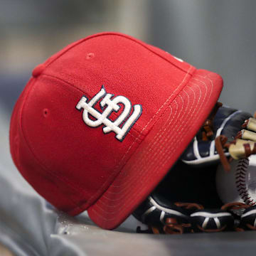 Sep 17, 2018; Atlanta, GA, USA; Detailed view of a St. Louis Cardinals hat and glove in the dugout against the Atlanta Braves in the first inning at SunTrust Park. Mandatory Credit: Brett Davis-Imagn Images
