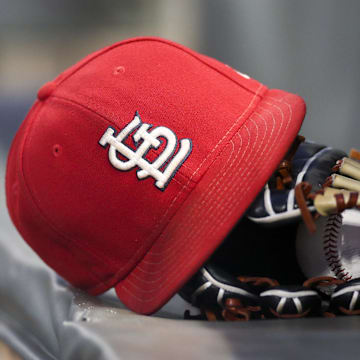 Sep 17, 2018; Atlanta, GA, USA; Detailed view of a St. Louis Cardinals hat and glove in the dugout against the Atlanta Braves in the first inning at SunTrust Park. Mandatory Credit: Brett Davis-Imagn Images
