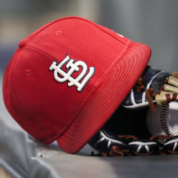 Sep 17, 2018; Atlanta, GA, USA; Detailed view of a St. Louis Cardinals hat and glove in the dugout against the Atlanta Braves in the first inning at SunTrust Park. Mandatory Credit: Brett Davis-Imagn Images
