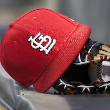 Sep 17, 2018; Atlanta, GA, USA; Detailed view of a St. Louis Cardinals hat and glove in the dugout against the Atlanta Braves in the first inning at SunTrust Park. Mandatory Credit: Brett Davis-Imagn Images
