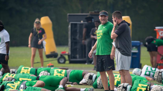 Oregon defensive coordinator Tosh Lupoi, left, and head coach Dan Lanning talk during practice Wednesday, Aug. 16, 2023, in E