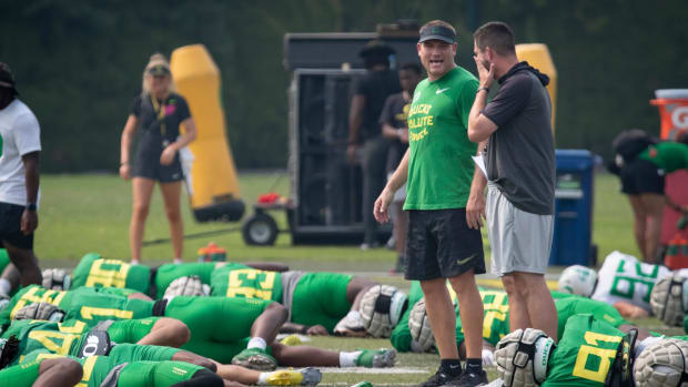 Oregon defensive coordinator Tosh Lupoi, left, and head coach Dan Lanning talk during practice Wednesday