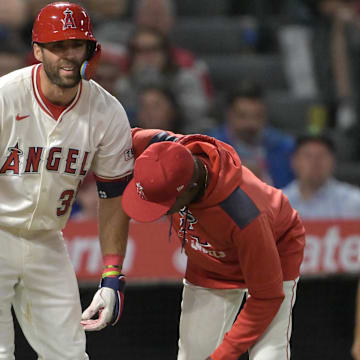 Jun 9, 2025; Anaheim, California, USA;  Los Angeles Angels manager Ron Washington (37) checks on center fielder Chris Taylor (33) after he was hit by a pitch in the left hand in the eighth inning against the Athletics at Angel Stadium. Taylor was diagnosed with a fracture in the hand. Mandatory Credit: Jayne Kamin-Oncea-Imagn Images