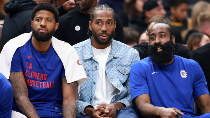 Apr 12, 2024; Los Angeles, California, USA;  Los Angeles Clippers forward Paul George (13, left) and forward Kawhi Leonard (2, center) and guard James Harden (1, right) watch the game from the bench during the third quarter against the Utah Jazz at Crypto.com Arena. 