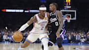Oct 28, 2025; Oklahoma City, Oklahoma, USA; Oklahoma City Thunder guard Shai Gilgeous-Alexander (2) drives past Sacramento Kings guard Malik Monk (0) during the second half at Paycom Center. Mandatory Credit: Alonzo Adams-Imagn Images