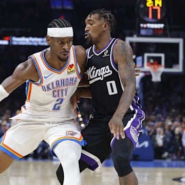 Oct 28, 2025; Oklahoma City, Oklahoma, USA; Oklahoma City Thunder guard Shai Gilgeous-Alexander (2) drives past Sacramento Kings guard Malik Monk (0) during the second half at Paycom Center. Mandatory Credit: Alonzo Adams-Imagn Images