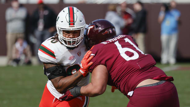 Virginia Tech Hokies offensive lineman Braelin Moore (61) blocks Miami Hurricanes defensive lineman Akheem Mesidor (90)