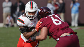 Oct 15, 2022; Blacksburg, Virginia, USA;  Virginia Tech Hokies offensive lineman Braelin Moore (61) blocks Miami Hurricanes defensive lineman Akheem Mesidor (90) during the second half at Lane Stadium. Mandatory Credit: Reinhold Matay-Imagn Images