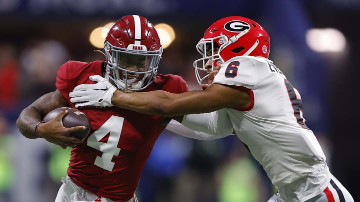 Jalen Milroe #4 of the Alabama Crimson Tide is pursued by Daylen Everette #6 of the Georgia Bulldogs during the first quarter in the SEC Championship at Mercedes-Benz Stadium on December 2, 2023 in Atlanta, Georgia.