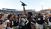 Purdue Boilermakers offensive lineman Mahamane Moussa holds the Purdue Cannon after beating rival Illinois in 2023.