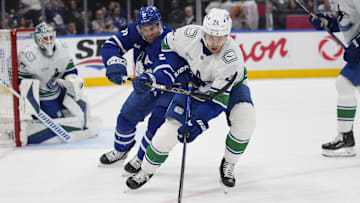 Jan 11, 2025; Toronto, Ontario, CAN; Vancouver Canucks forward Pius Suter (24) controls the puck against Toronto Maple Leafs forward John Tavares (91) during the first period at Scotiabank Arena. Mandatory Credit: John E. Sokolowski-Imagn Images