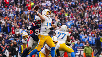 Dec 28, 2024; Foxborough, Massachusetts, USA; Los Angeles Chargers quarterback Justin Herbert (10) under pressure from New England Patriots defensive end Keion White (99) in the second half at Gillette Stadium. Mandatory Credit: David Butler II-Imagn Images