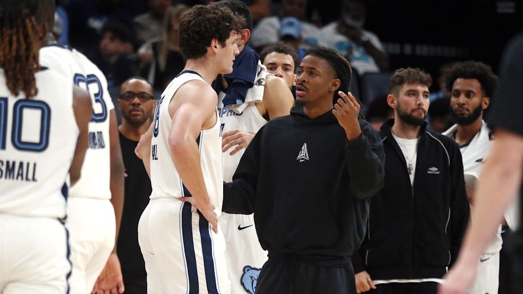 Oct 8, 2025; Memphis, Tennessee, USA; Memphis Grizzlies guard Ja Morant (12) talks with center PJ Hall (16) during a timeout during the second quarter against the Boston Celtics at FedExForum. Mandatory Credit: Petre Thomas-Imagn Images