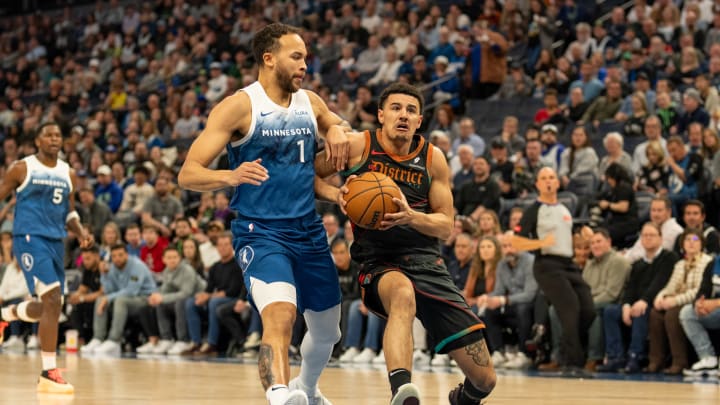 Washington Wizards guard Johnny Davis (1) drives on Minnesota Timberwolves forward Kyle Anderson (1) and scores in the first quarter at Target Center in Minneapolis on April 9, 2024. 