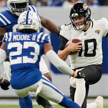 Jacksonville Jaguars quarterback Mac Jones (10) slides as Indianapolis Colts cornerback Kenny Moore II (23) moves in to tackle Sunday, Jan. 5, 2025, during a game against the Jacksonville Jaguars at Lucas Oil Stadium in Indianapolis.