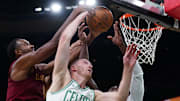 Oct 29, 2025; Boston, Massachusetts, USA; Cleveland Cavaliers center Evan Mobley (4) works for the ball against Boston Celtics forward Sam Hauser (30) and guard/forward Jaylen Brown (7) in the second half at TD Garden. Mandatory Credit: David Butler II-Imagn Images