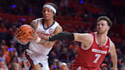 Dec 10, 2024; Champaign, Illinois, USA;  Wisconsin Badgers forward Carter Gilmore (7) reaches for the ball as Illinois Fighting Illini guard Tre White (22) pulls away a rebound during the first half at State Farm Center. Mandatory Credit: Ron Johnson-Imagn Images