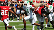 Sep 14, 2024; Lubbock, Texas, USA;  North Texas Mean Green running back Damashja Harris (44) runs the ball against Texas Tech Red Raiders defensive back Chapman Lewis (25) in the first half at Jones AT&T Stadium and Cody Campbell Field. Mandatory Credit: Michael C. Johnson-Imagn Images