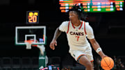 Nov 23, 2025; Coral Gables, Florida, USA; Miami Hurricanes forward Shelton Henderson (7) drives to the basket against Delaware State Hornets guard John Clemmons (5) during the second half at Watsco Center. Mandatory Credit: Sam Navarro-Imagn Images