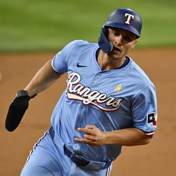 Sep 1, 2024; Arlington, Texas, USA; Texas Rangers shortstop Corey Seager (5) scores from second base on a double hit by right fielder Adolis Garcia (not pictured) during the first inning at Globe Life Field. Mandatory Credit: Jerome Miron-Imagn Images