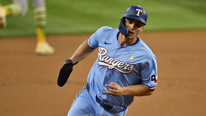 Sep 1, 2024; Arlington, Texas, USA; Texas Rangers shortstop Corey Seager (5) scores from second base on a double hit by right fielder Adolis Garcia (not pictured) during the first inning at Globe Life Field. Mandatory Credit: Jerome Miron-Imagn Images