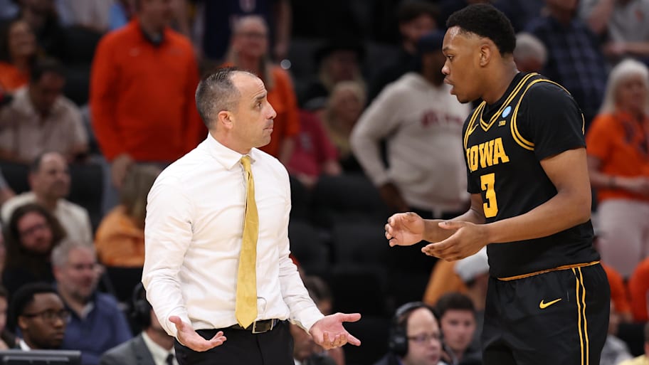 Iowa Hawkeyes head coach Ben McCollum talks with forward Cam Manyawu.