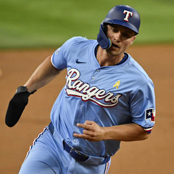 Sep 1, 2024; Arlington, Texas, USA; Texas Rangers shortstop Corey Seager (5) scores from second base on a double hit by right fielder Adolis Garcia (not pictured) during the first inning at Globe Life Field.