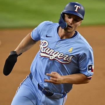 Sep 1, 2024; Arlington, Texas, USA; Texas Rangers shortstop Corey Seager (5) scores from second base on a double hit by right fielder Adolis Garcia (not pictured) during the first inning at Globe Life Field. 