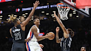 Nov 7, 2025; Brooklyn, New York, USA;  Detroit Pistons guard Ausar Thompson (9) drives in between Brooklyn Nets forward Noah Clowney (21) and center Nic Claxton (33) in the second quarter at Barclays Center. Mandatory Credit: Wendell Cruz-Imagn Images