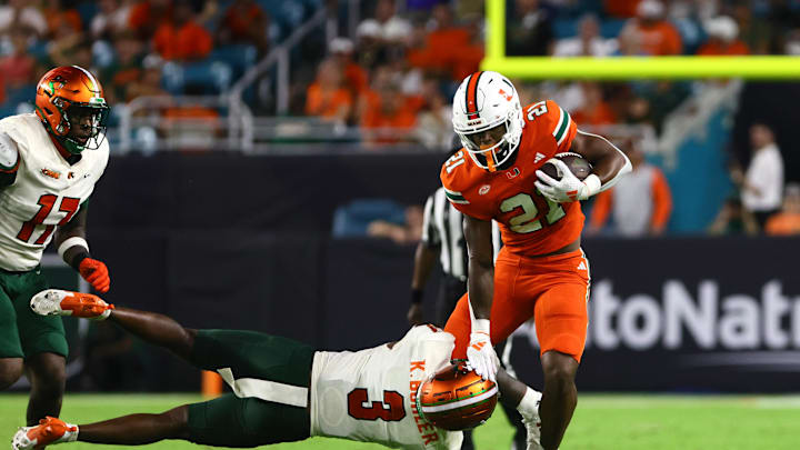 Sep 7, 2024; Miami Gardens, Florida, USA; Miami Hurricanes running back Jordan Lyle (21) breaks a tackle against Florida A&M Rattlers defensive back Kendall Bohler (3) during the third quarter at Hard Rock Stadium. Mandatory Credit: Sam Navarro-Imagn Images
