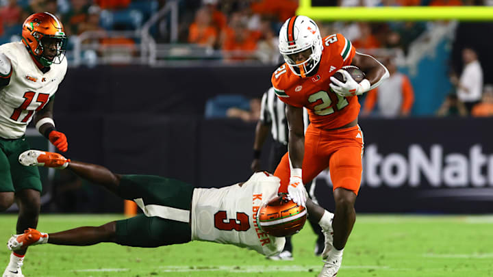 Sep 7, 2024; Miami Gardens, Florida, USA; Miami Hurricanes running back Jordan Lyle (21) breaks a tackle against Florida A&M Rattlers defensive back Kendall Bohler (3) during the third quarter at Hard Rock Stadium. Mandatory Credit: Sam Navarro-Imagn Images