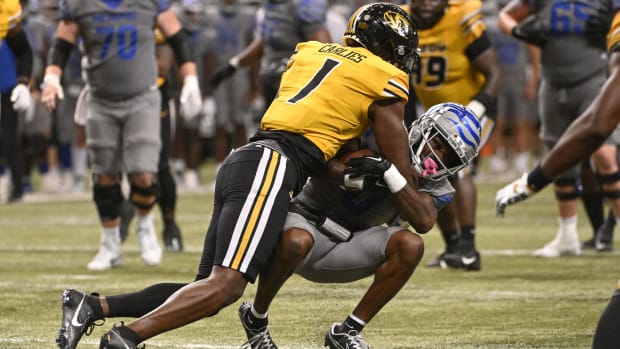 Colts linebacker Jaylon Carlies (yellow jersey; black letters/number) tackles a ball-carrier (grey jersey; blue stripe)