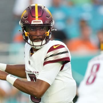 Aug 17, 2024; Miami Gardens, Florida, USA;  Washington Commanders quarterback Jayden Daniels (5) drops back to pass against the Miami Dolphins during the first quarter at Hard Rock Stadium. Mandatory Credit: Jim Rassol-USA TODAY Sports