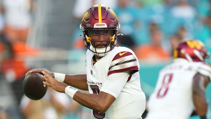 Aug 17, 2024; Miami Gardens, Florida, USA;  Washington Commanders quarterback Jayden Daniels (5) drops back to pass against the Miami Dolphins during the first quarter at Hard Rock Stadium. Mandatory Credit: Jim Rassol-USA TODAY Sports