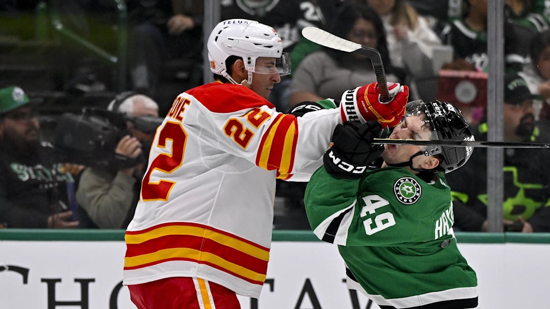 Apr 7, 2026; Dallas, Texas, USA; Calgary Flames center Ryan Strome (22) checks Dallas Stars center Justin Hryckowian (49) during the second period at the American Airlines Center. Mandatory Credit: Jerome Miron-Imagn Images